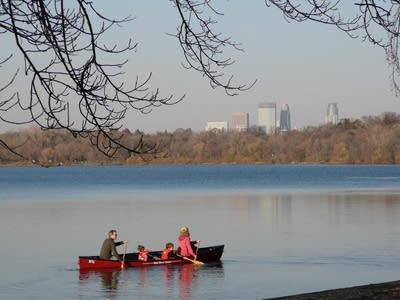 Four people canoeing on a lake