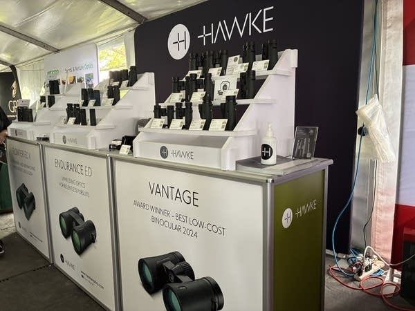 One of the many booths in the optics tent features a series of binoculars.