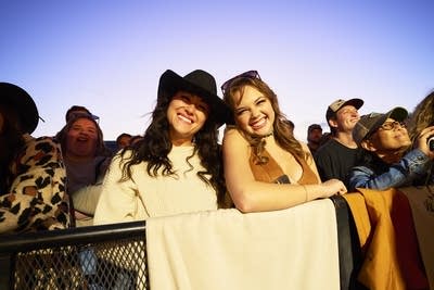 2 people posing for a photo at an outdoor concert