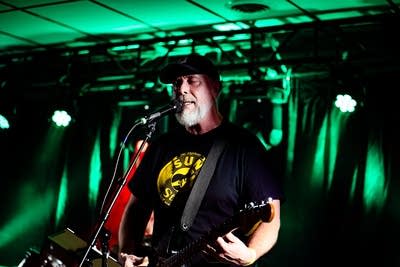 A musician sings and plays guitar onstage