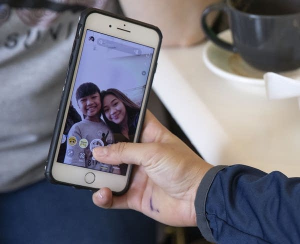 Close up of a phone as a teen takes a selfie with a girl.