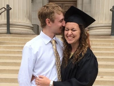 A couple kisses at graduation