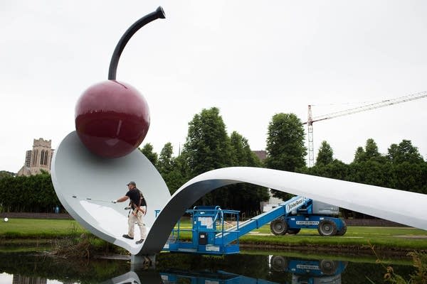 Tim Antilla paints artist Claes Oldenburg's Spoonbridge and Cherry Tuesday, June 18, 2013 at the Walker Art Center, Minneapolis Sculpture Garden.