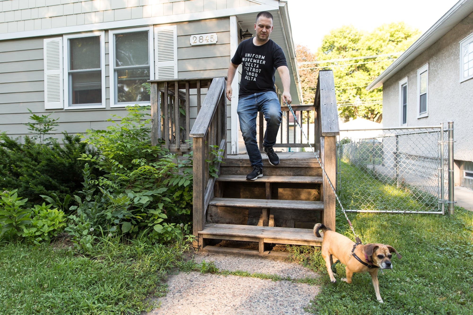 Holly leads Marlon Masanz, one of her owners, down the front stairs.