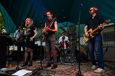 A rock band performing on an outdoor stage