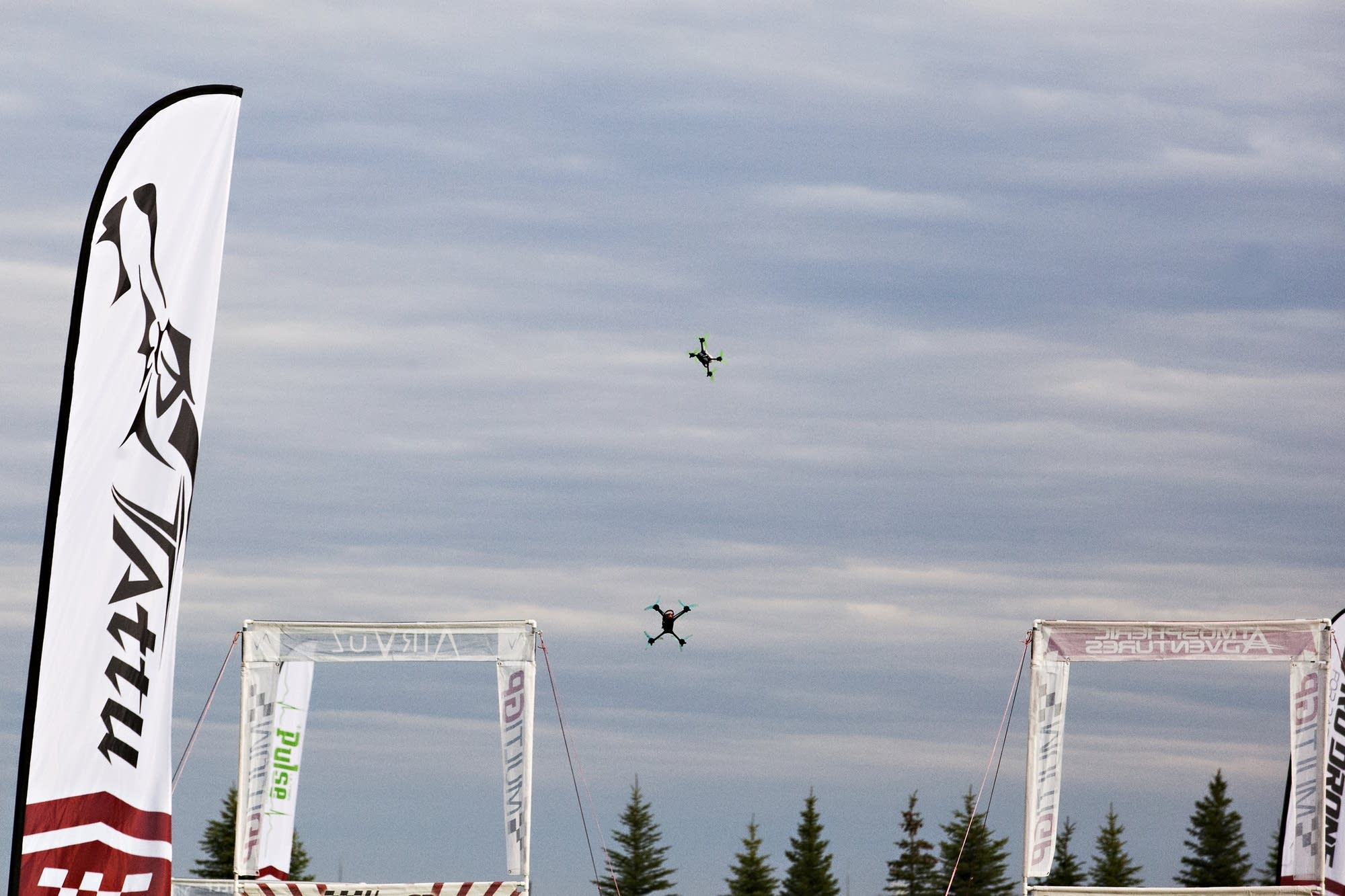 A pair of drones dot the sky during a race.