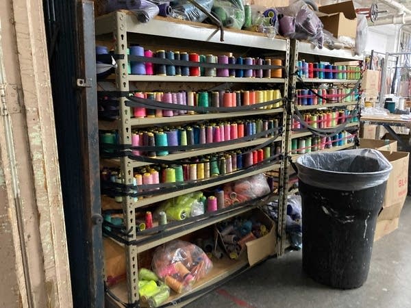 Racks of different colored spools of thread in a garment factory.