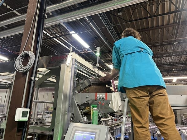 A man feeds boxes into machine