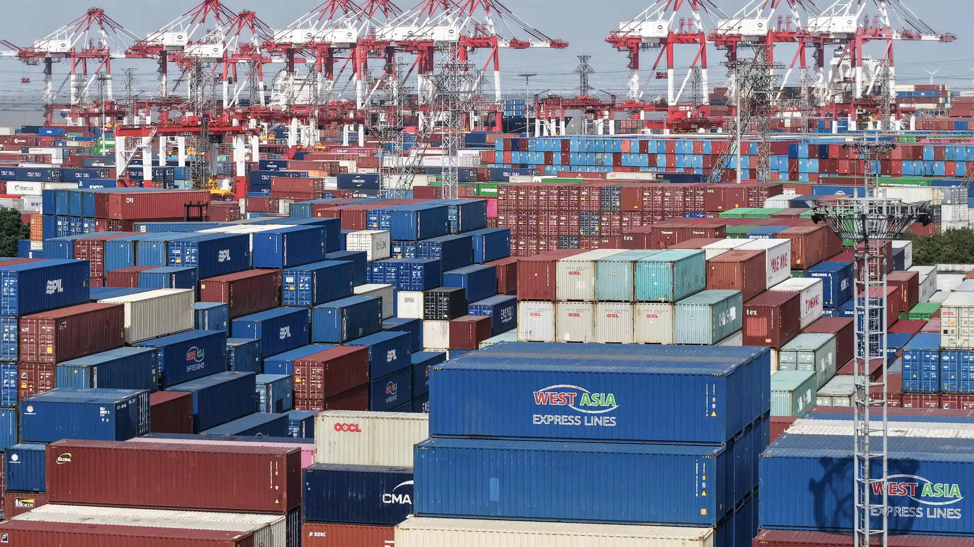 https://img.apmcdn.org/5e75baffa63a3ffe94beb553fbf8ba71fe68e1d0/widescreen/abf9c0-20260114-aerial-view-of-stacked-containers-at-a-port-terminal-webp2000.webp