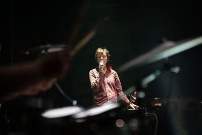 A musician sings and applies vocal effects onstage in a music club