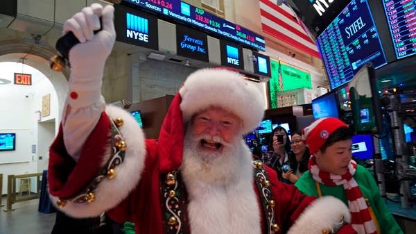 A man in a Santa Clause costume gestures on the floor at the closing bell of the Dow Industrial Average at the New York Stock Exchange on December 5, 2019 in New York.