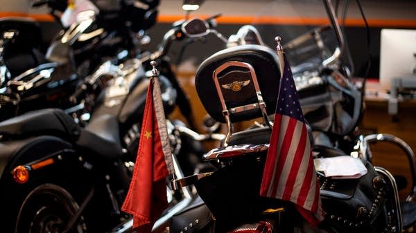 Chinese and US flags are seen on a Harley-Davidson motorcycle in the maintenance room of a dealership in Shanghai on August 24, 2018. - From Harley-Davidson motorcycles and US bourbon to Chinese parts and machinery, the world's two largest economies have exchanged punitive tariffs that slice through a wide swath of products.