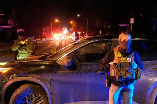 Police and federal agents form a crime scene at night in north Minneapolis.