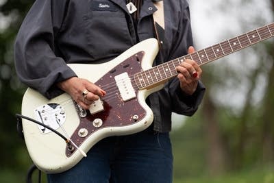 A musician plays guitar at an outdoor venue