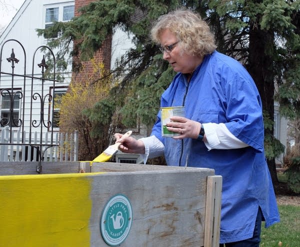 Moorhead Mayor Del Rae Williams paints her Little Free Garden.