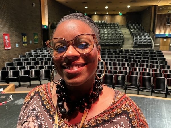 A woman stands for a photo in an auditorium