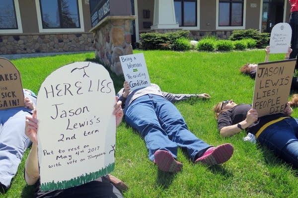 About 50 protesters gathered outside of Rep. Lewis's Burnsville office.