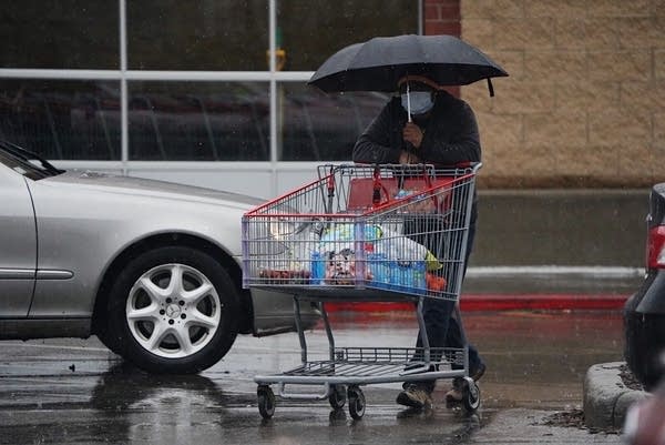 A shopper wearing a mask leaves Costco.