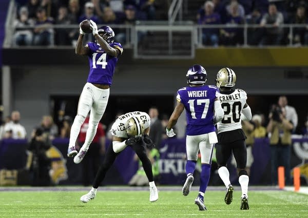 Stefon Diggs (#14) of the Minnesota Vikings leaps to catch the ball.