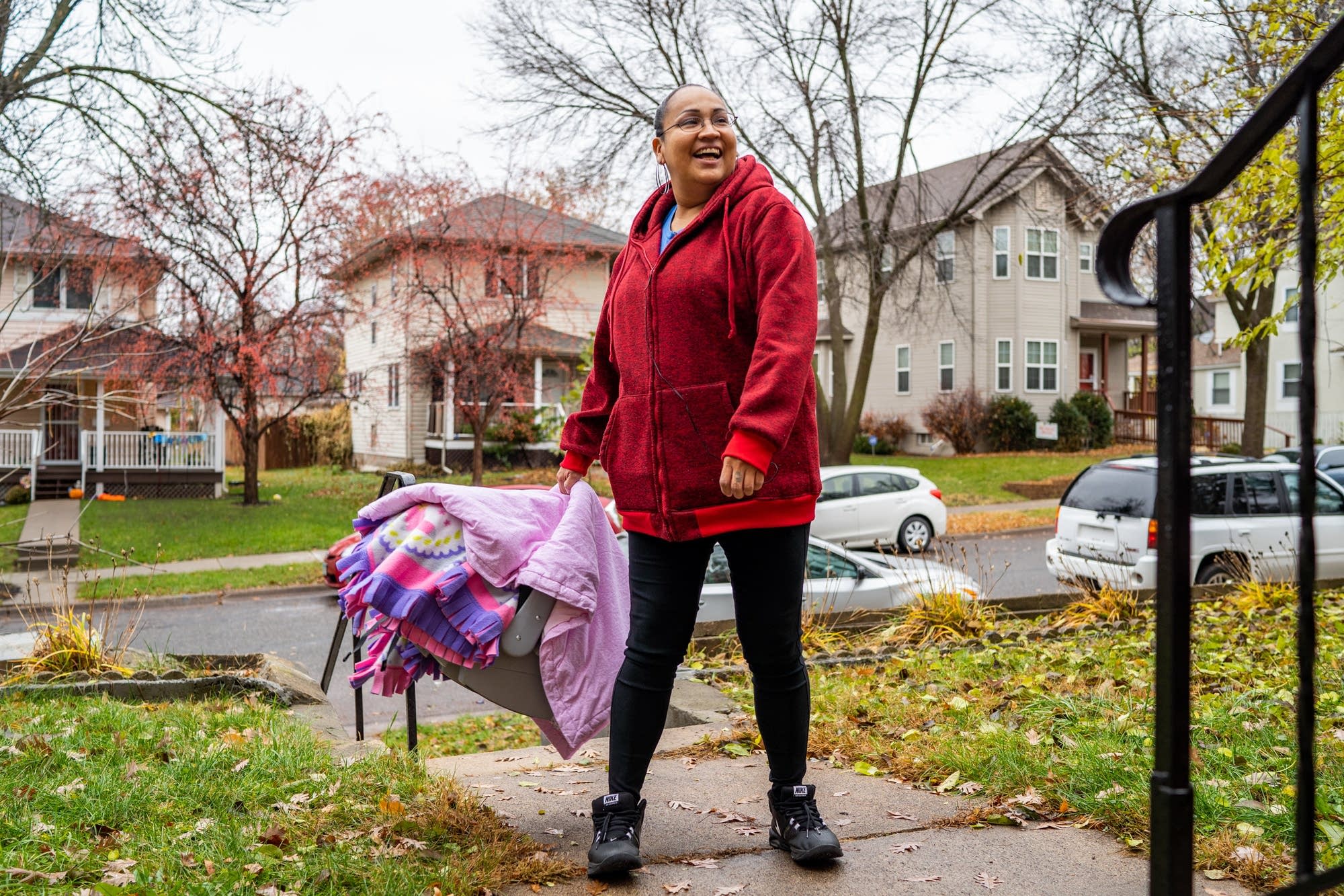Melody Johnson gently swings her baby carrier to calm her infant.