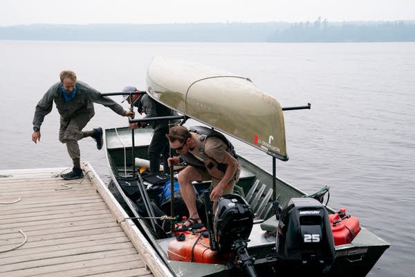 Two men get out of a small boat