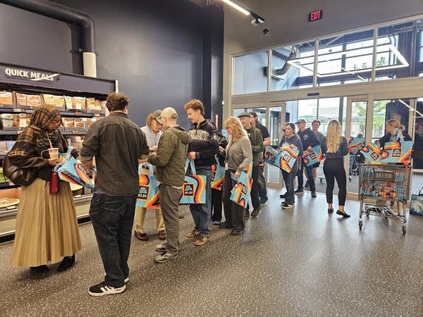 People receive tote bags inside grocery store