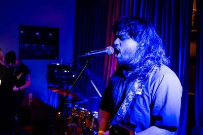 a man playing guitar and singing on stage