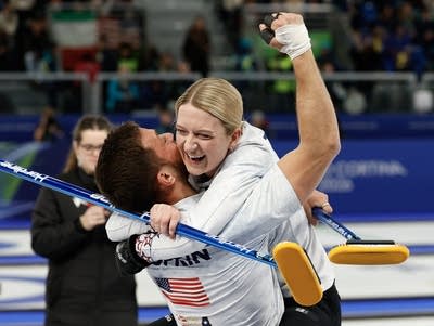 Two curlers celebrate after a win