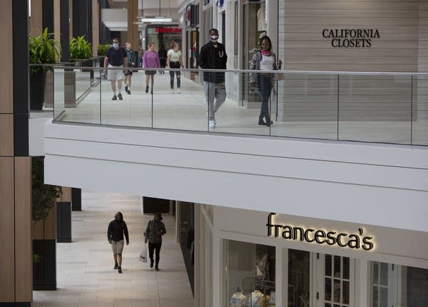 Shoppers walk through a mall. 