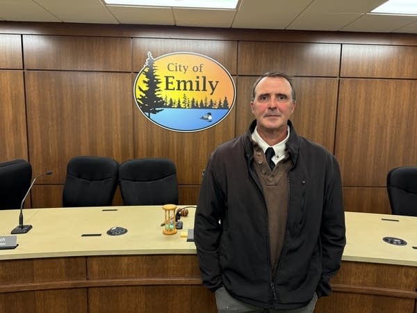 portrait of a man standing in front of a sign