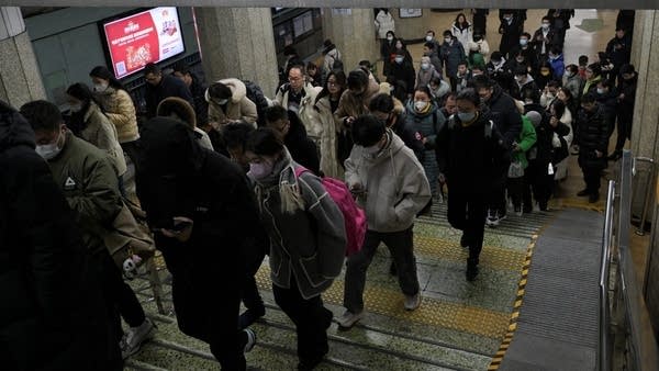 People walk through a Beijing subway station. 