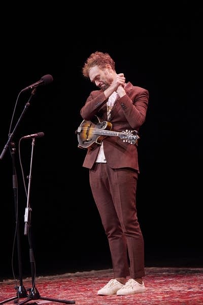 A musician gestures in gratitude to the audience