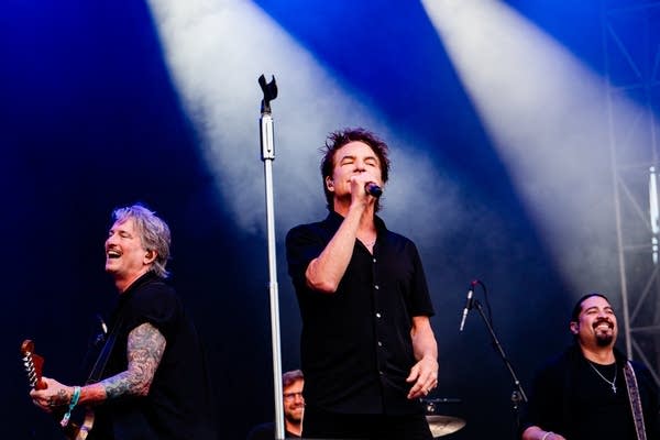 Three musicians performing together onstage