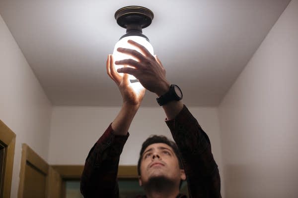 Andy Nail installs a high efficiency lightbulb. 