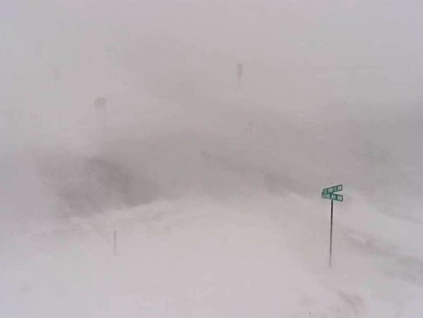 A lone signpost is visible as blizzard conditions sweep across a highway