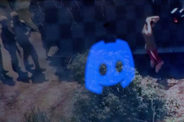 This photo illustration created on April 13, 2023 in Washington, DC, shows the Discord logo reflected in a screengrab of the suspect, national guardsman Jack Teixeira, being taken into custody by FBI agents in a forested area in North Dighton, in the northeastern state of Massachusetts. - FBI agents arrested a young national guardsman suspected of being behind a major leak of sensitive US government secrets -- including about the Ukraine war. US Attorney General Merrick Garland announced the arrest made "in connection with an investigation into alleged unauthorized removal, retention and transmission of classified national defense information."