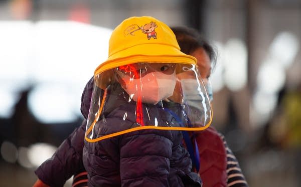 A mother and son waiting for the first train from Wuhan.