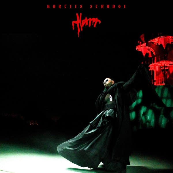 A man in a Darth Vader-style robe strikes a dance pose