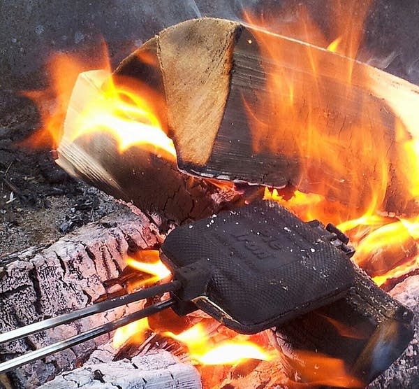 Cooking over the fire with a pie iron.