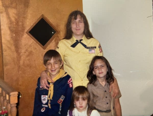A woman and three children in cub scout uniforms.