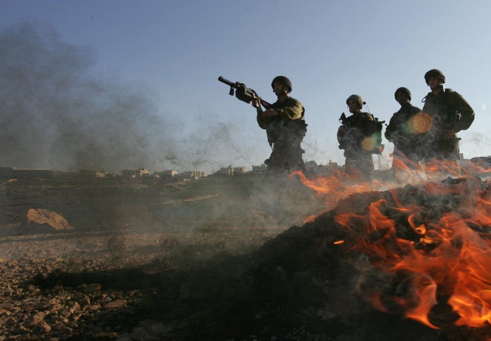 An Israeli soldier prepares to fire tear