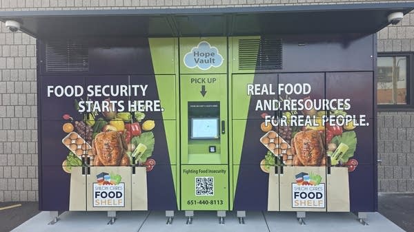 A row of outdoor lockers painted with food and the words "hope vault"