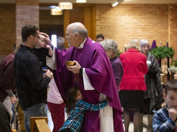 Father Paul of Saint Bridget's Saint Austin campus blesses Kyle Peltier.