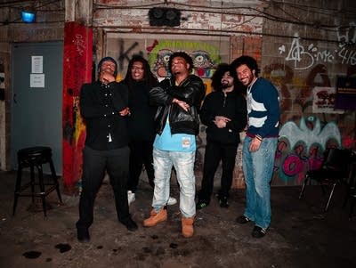 Five people pose for a photo in a garage.