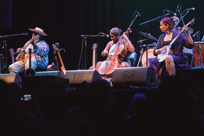 Three musicians performing together onstage