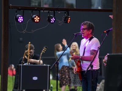 a man playing guitar and singing on stage