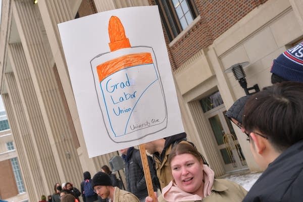 A woman holds a sign at a rally