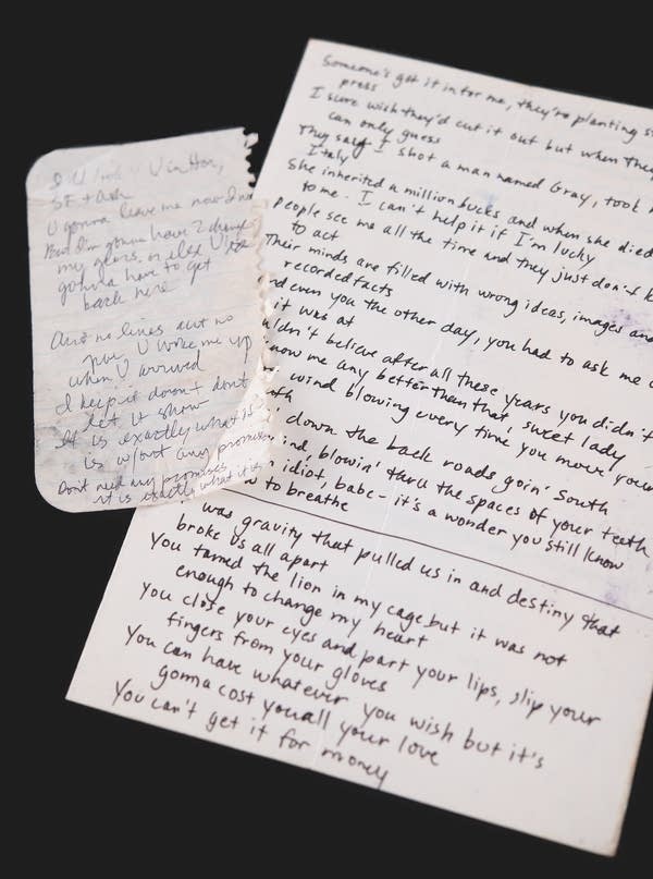 Two sheets of scratch paper with lyrics written on them.