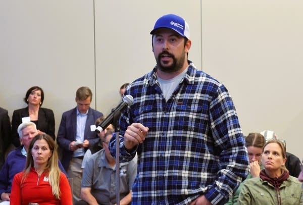 A man in a plaid shirt talks
