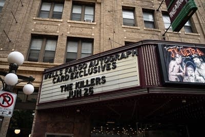 A theater marquee with concert info posted